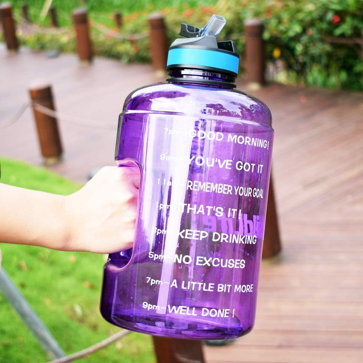 A person holding the water bottle by its handle