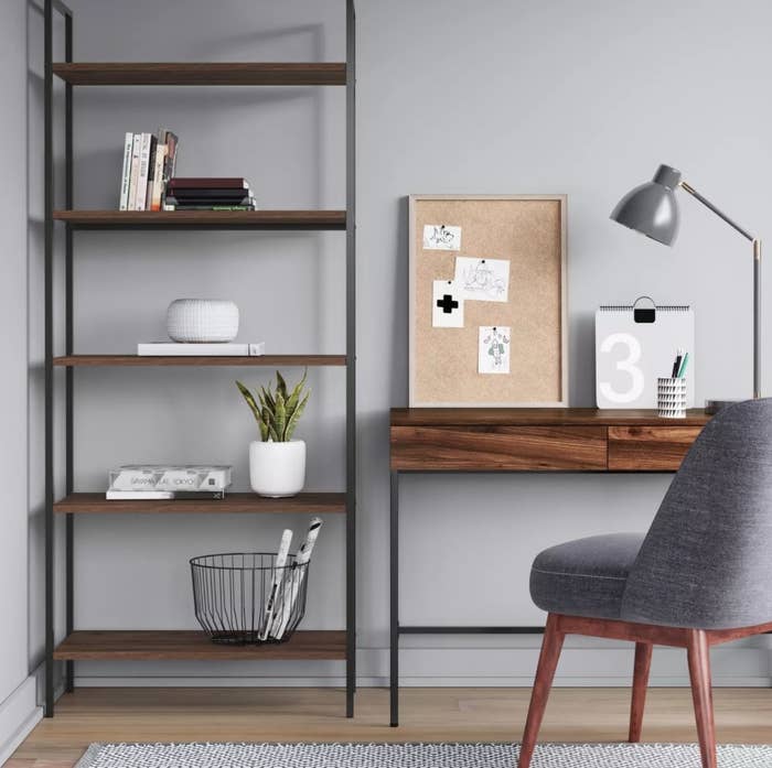 The ladder bookshelf in an office with books and plants set on top 