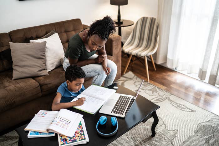 Mother helping son doing homework using laptop