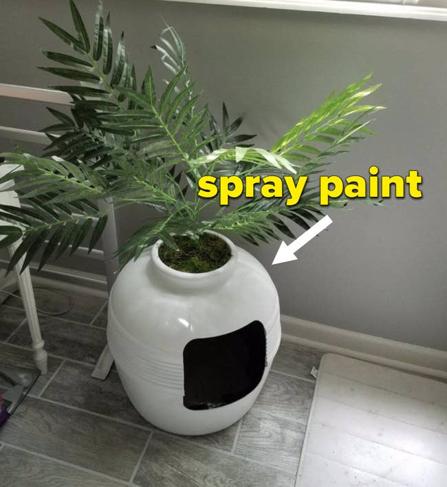 A white hidden litter box planter with a white arrow pointing to it and the words 
