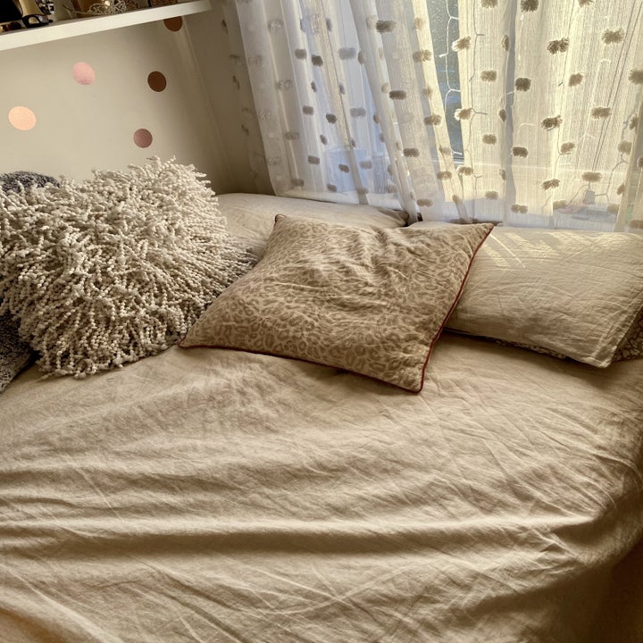 buzzfeed editor's bed with the oatmeal linen bedsheets on it 