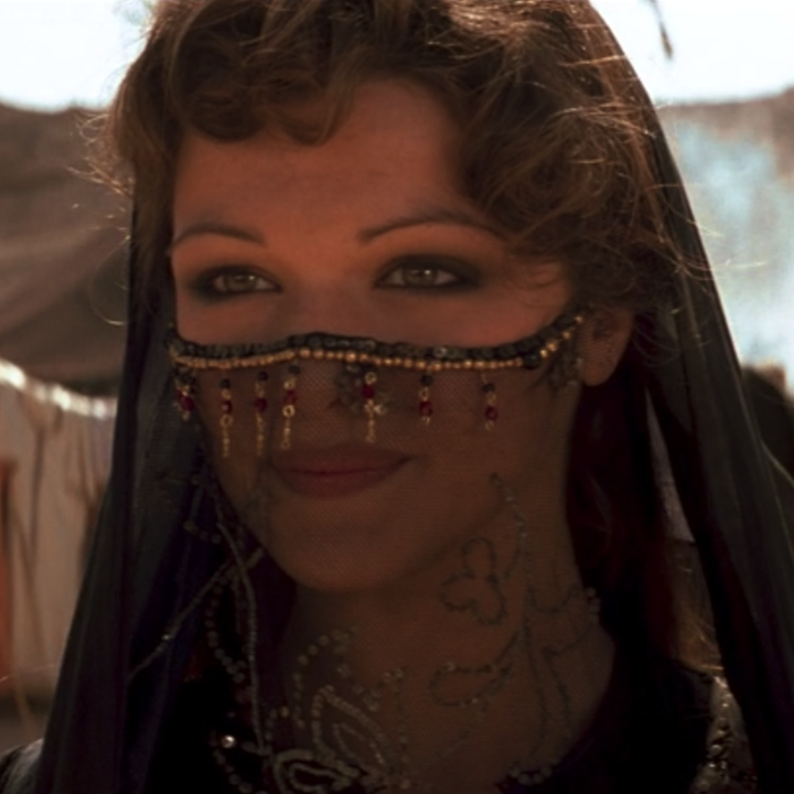 A close up of Evie who is wearing a black gown with a veil