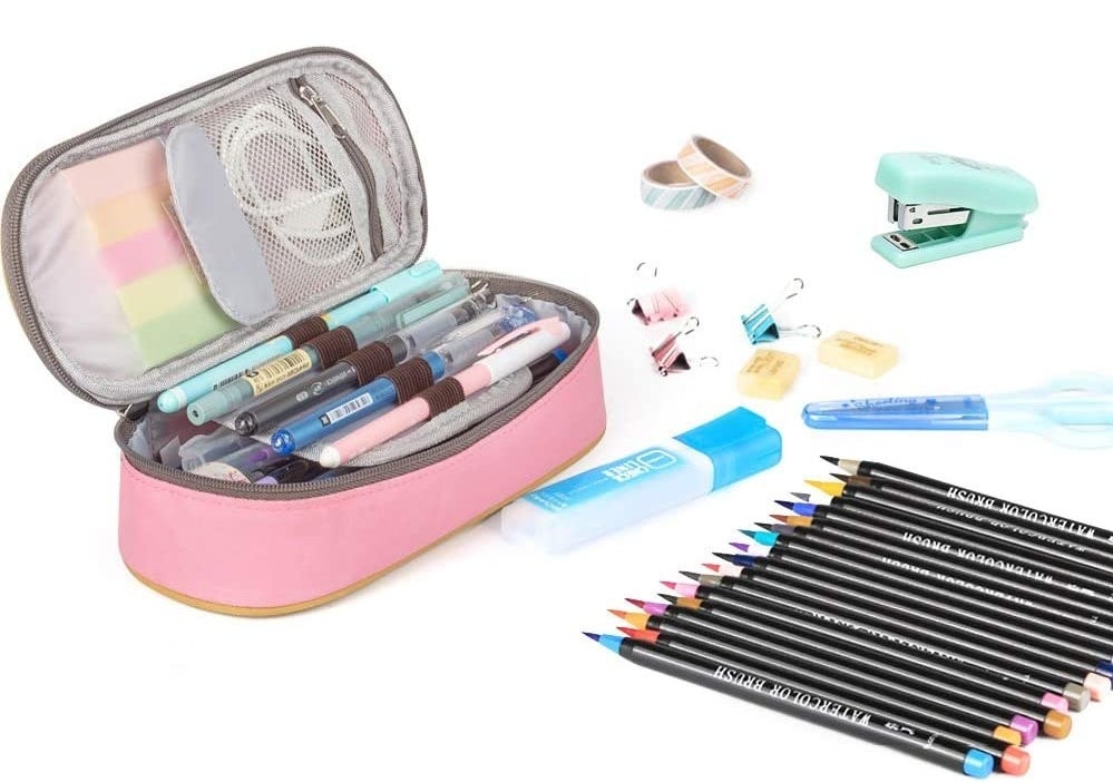 the pencil case with pens in it and stationery around it