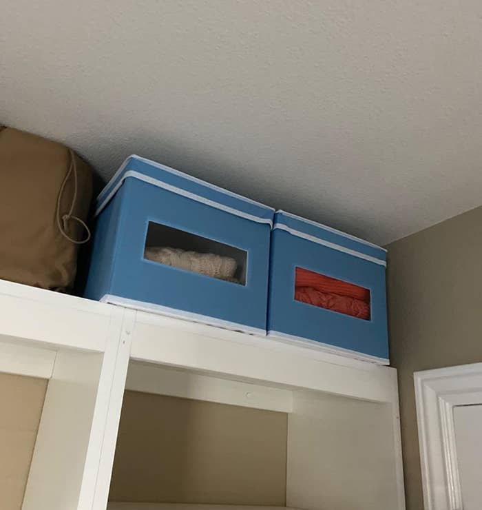 reviewer image of two light blue mDesign fabric storage boxes on top of a closet