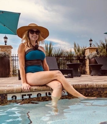 A reviewer sitting in the teal swimsuit