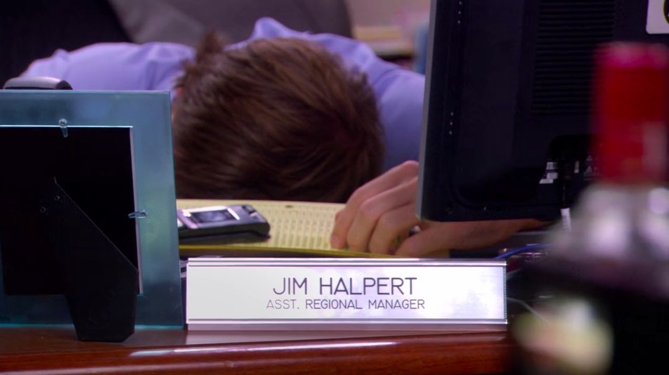 Jim sleeping at his desk, revealing his nameplate 