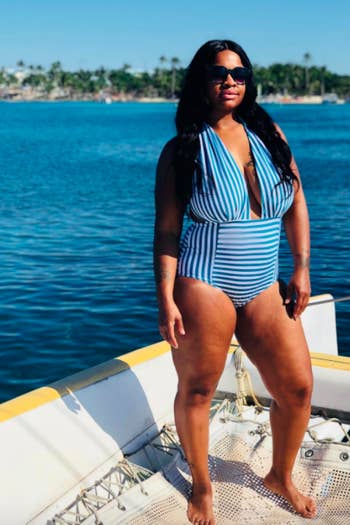 reviewer wearing the blue striped bathing suit on a boat