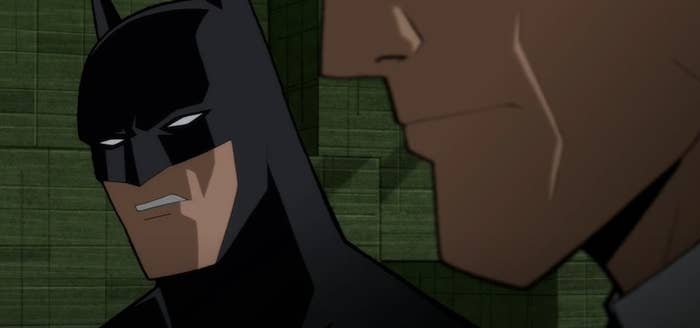 Batman talking to Harvey Dent near stacks of cash
