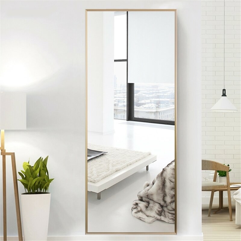 large rectangular mirror with gold trim mounted on a wall