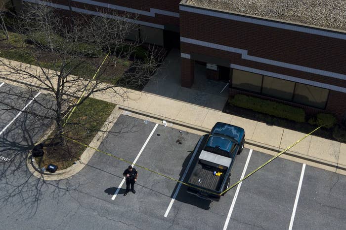 An aerial shot shows a cop standing near a taped-off area at the scene of a shooting