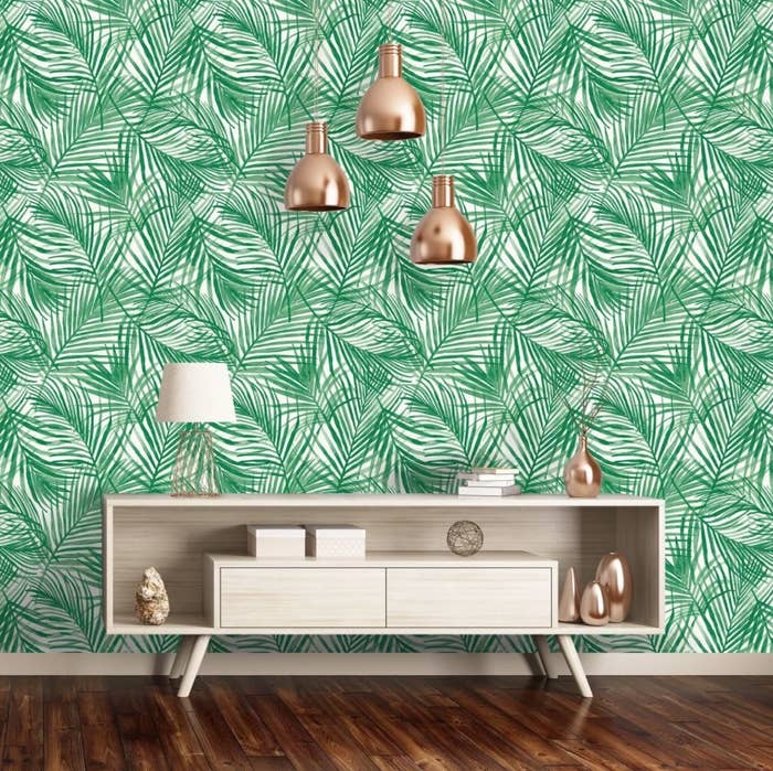 The wallpaper which is green and has tropical leaf patterns 