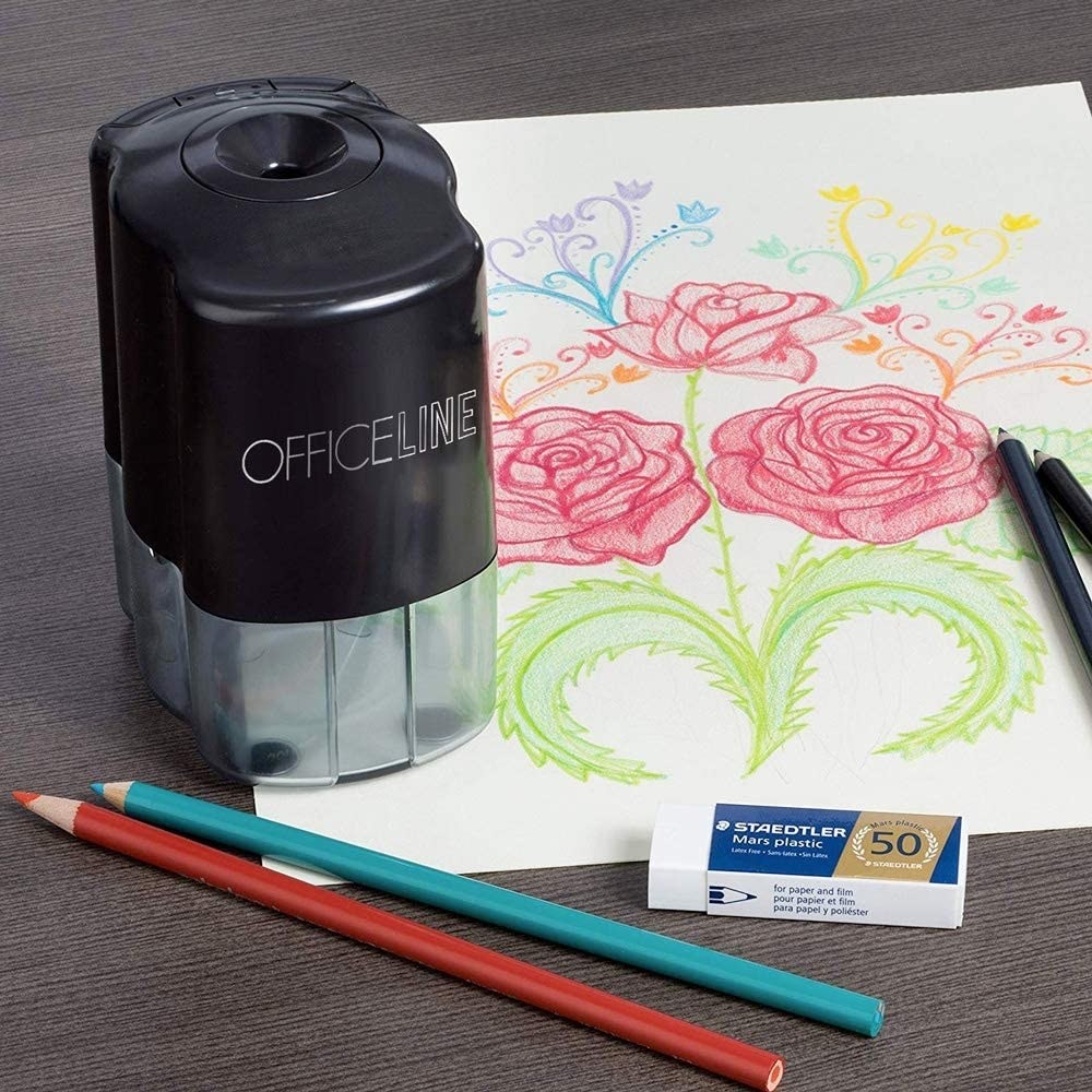 the pencil sharpener on a piece of paper next to two pencil crayons and an eraser