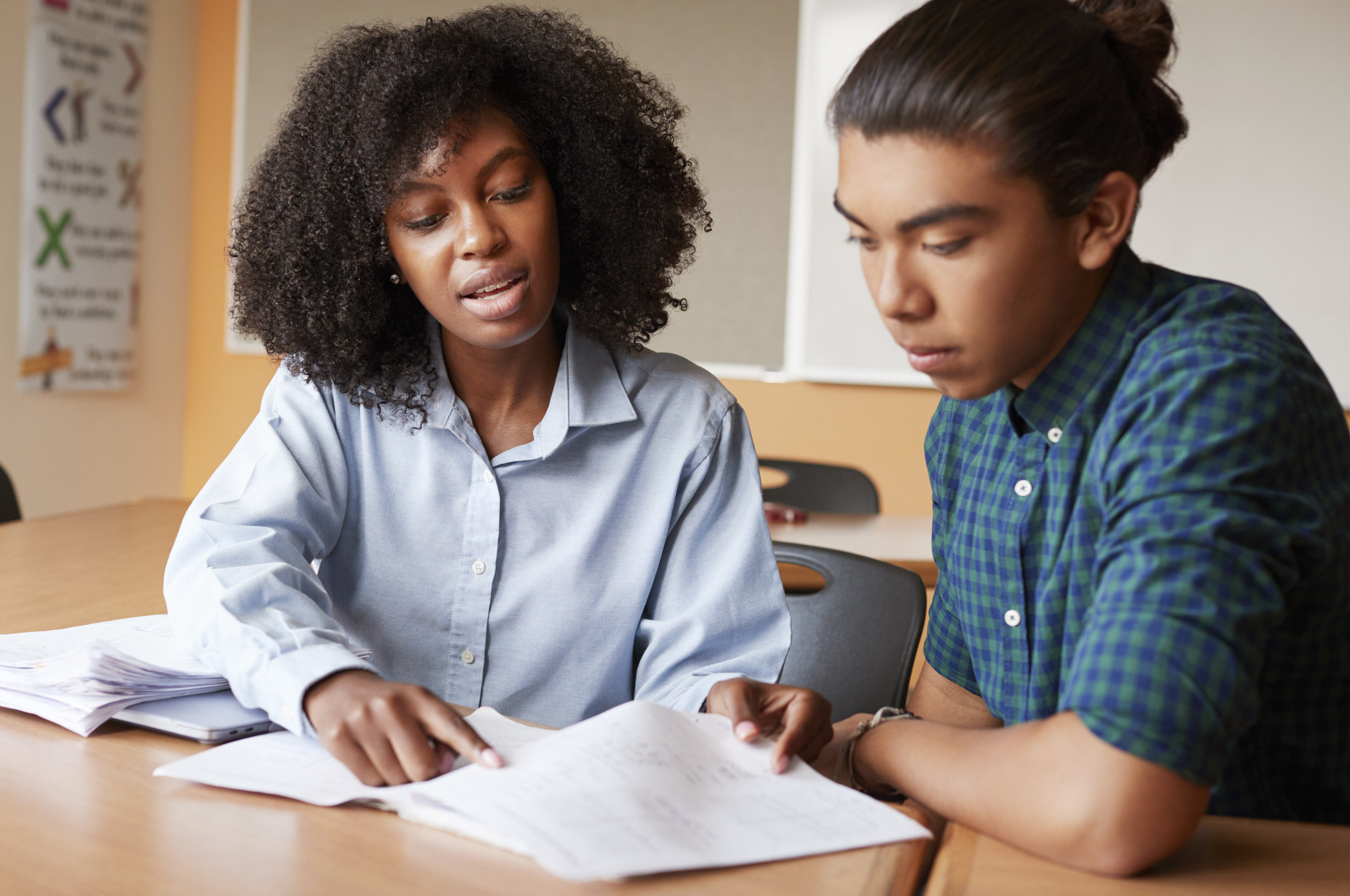 A teacher helping a teen student