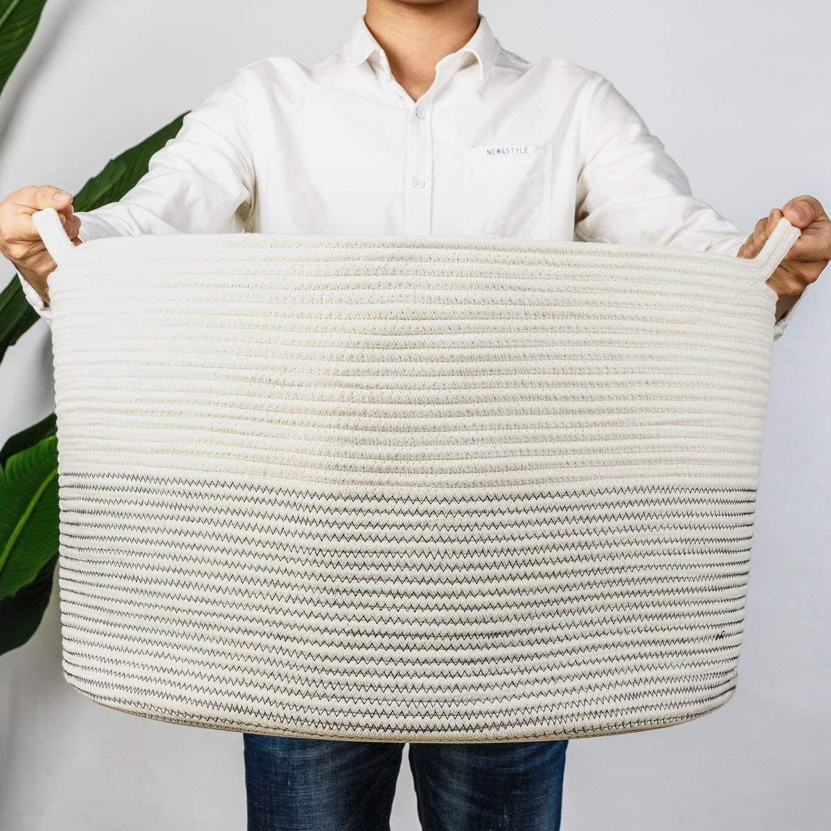 A person holding up an oversized rope basket