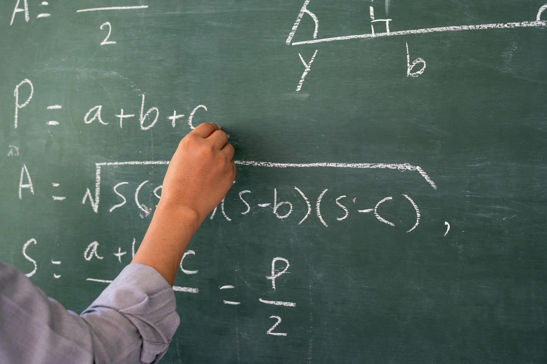 a hand writing on a chalkboard