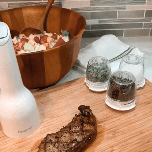 a gif of someone using the space, putting a a spice pod in it, and grinding fresh spice over a steak 