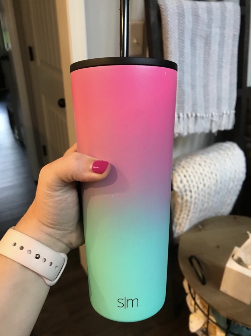 Reviewer holding their tall tumbler in pink to teal ombre design 