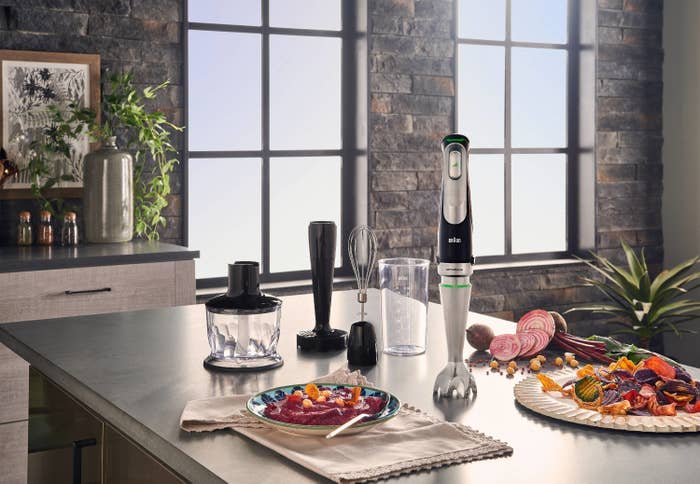 the blender and attachments on a counter with food