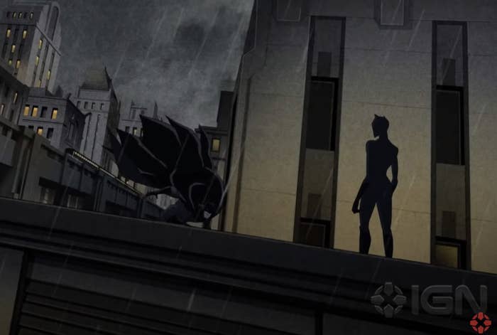 Catwoman stands on top of a building with Batman