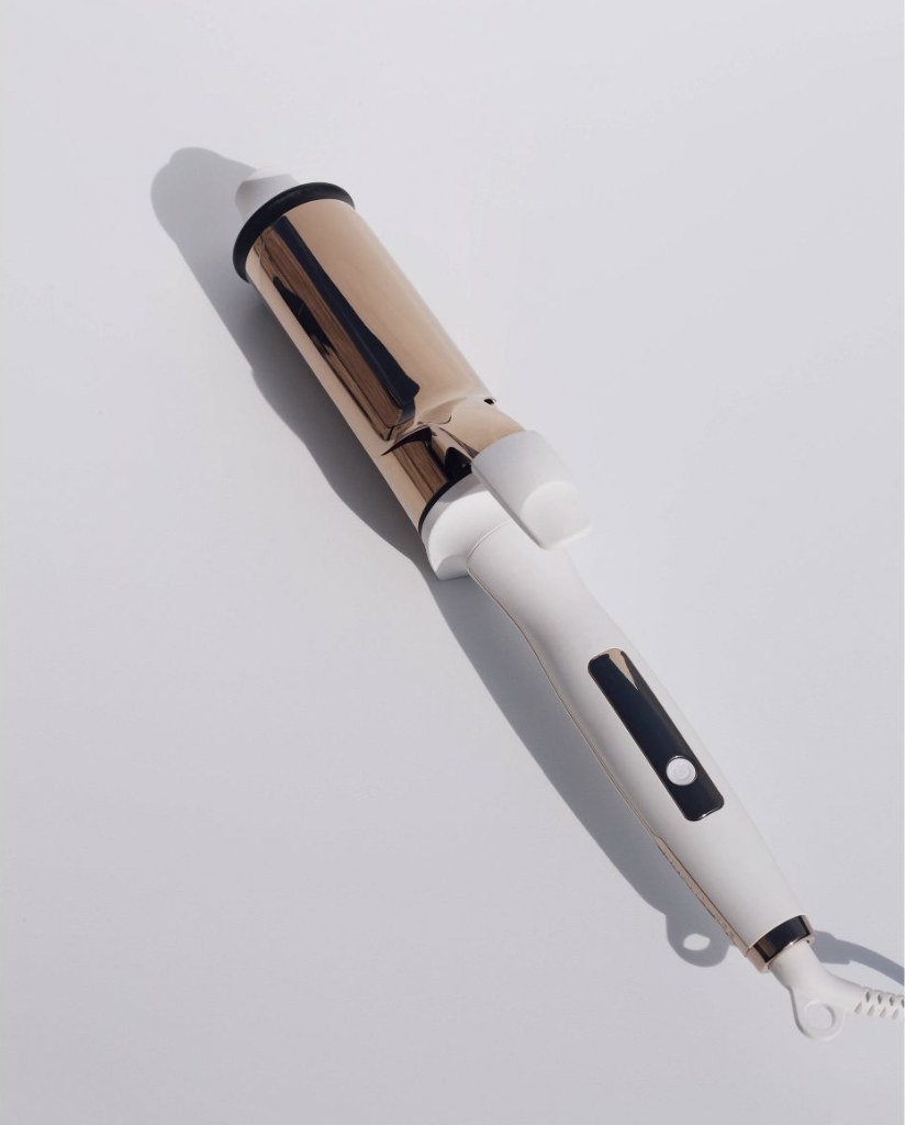 A white two inch curling iron with a gold barrel