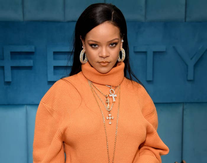 Rihanna wears an orange turtleneck at a Fenty event
