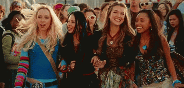 Cloe, Jade, Yasmine, and Sasha link arms and walk through a crowd together