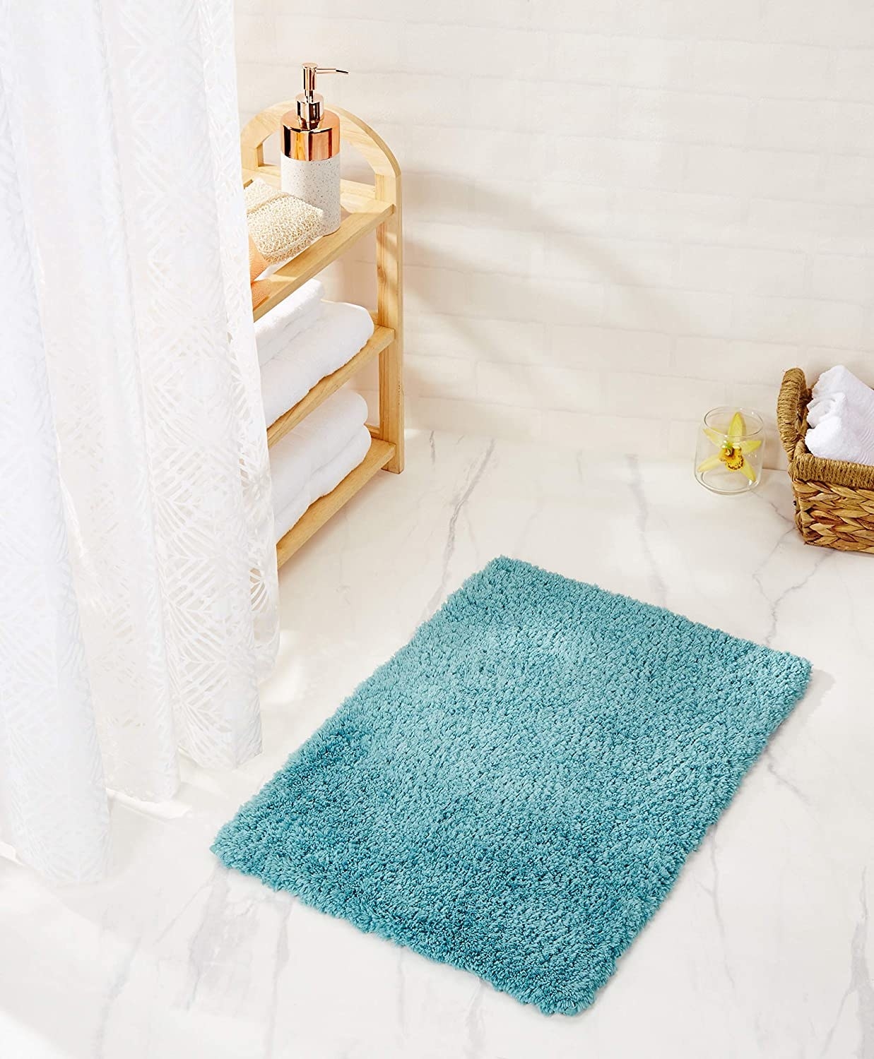 A turquoise bath mat on the floor 