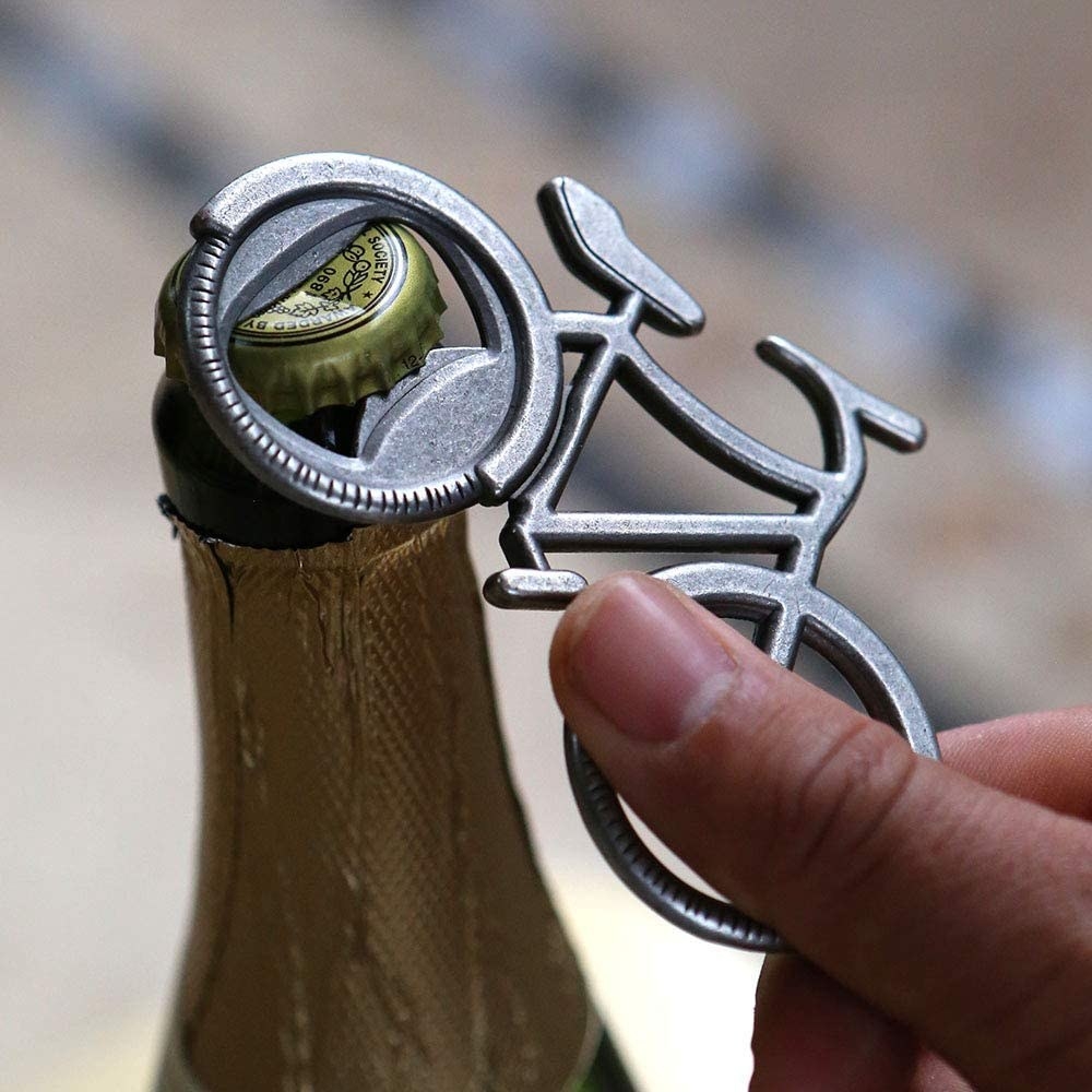 A person opening a beer with the bottle opener