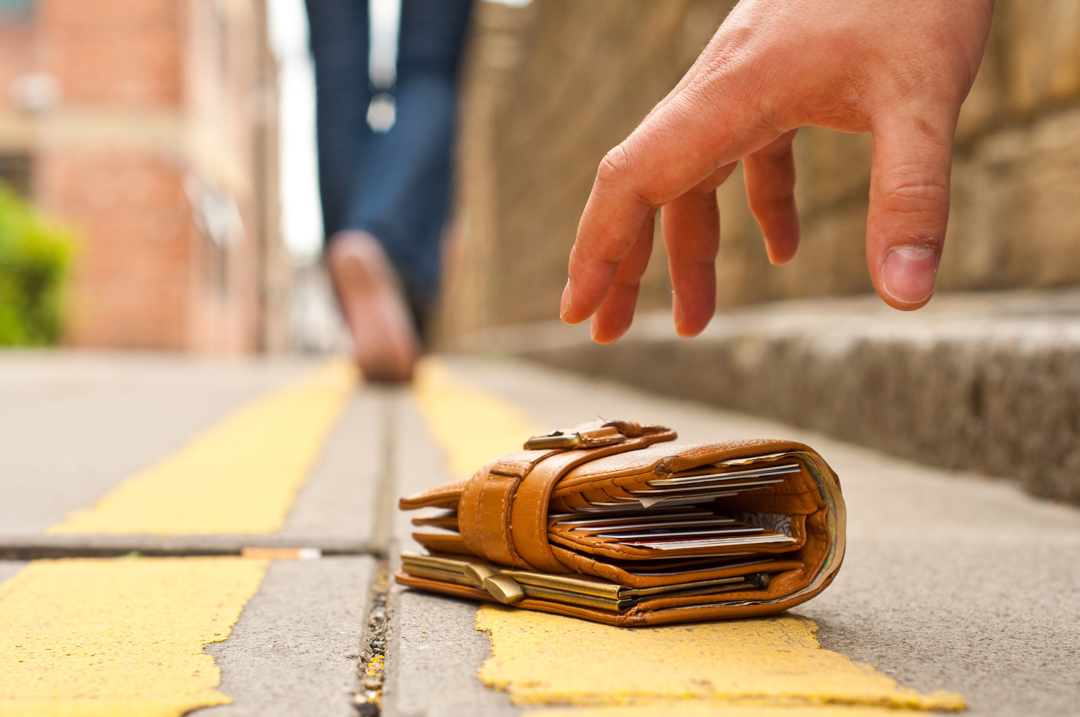 Thief picking up a lost wallet off the street