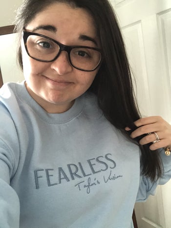 buzzfeed editor wearing a light blue crewneck with 