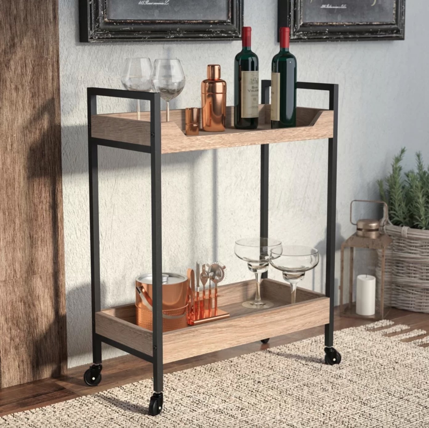 The bar cart in charter oak holding glasses, wine bottles, and cocktail kits