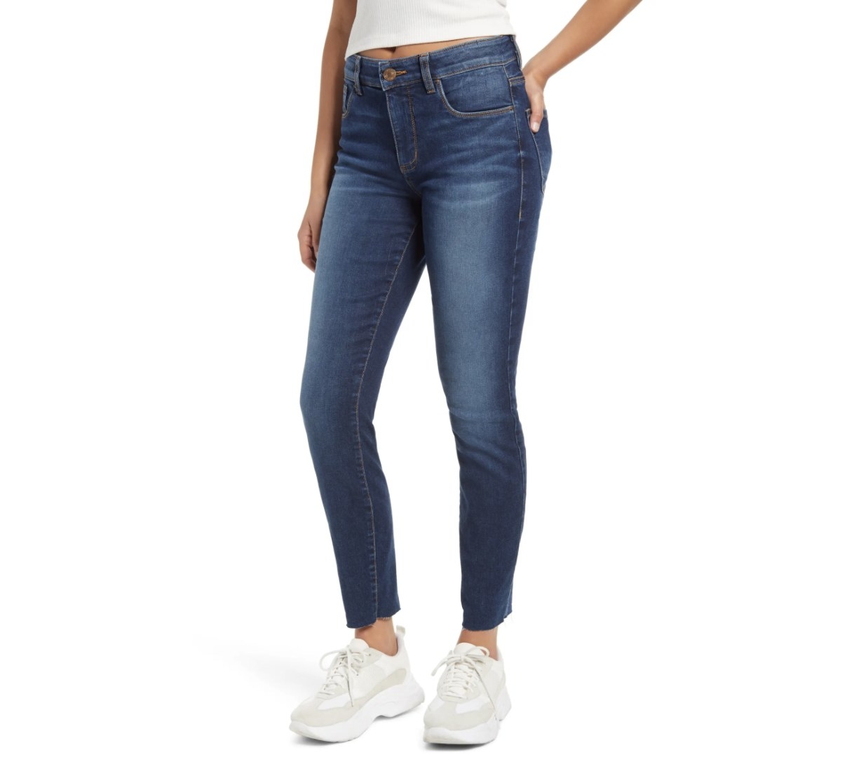 Model is wearing denim blue jeans and white sneakers