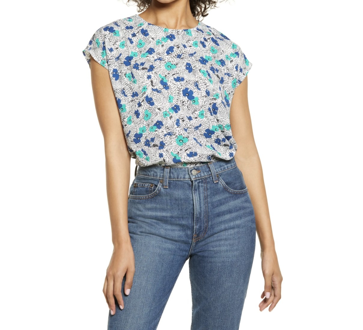 Model is wearing a patterned blouse and denim jeans