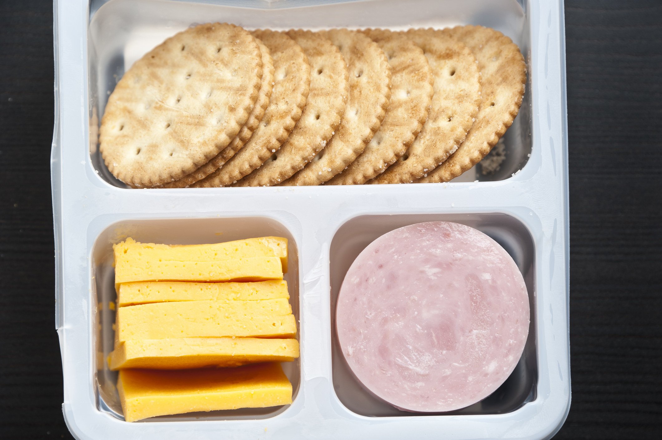 A close up of a Lunchables with crackers, cheese, and ham circles