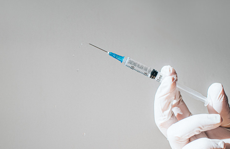 A gloved hand holding a syringe