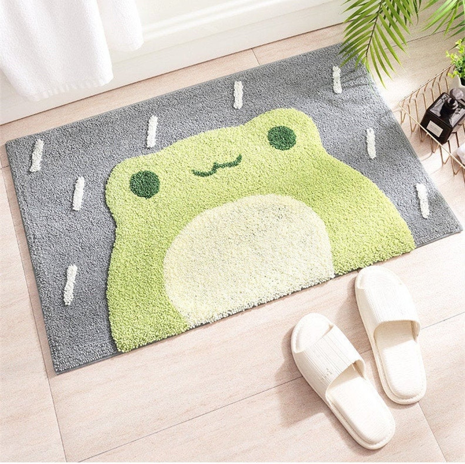 the green and gray frog doormat