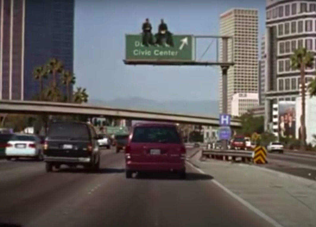 Nicolas Cage and Andre Braugher sitting on a road sign in &quot;City of Angels&quot;