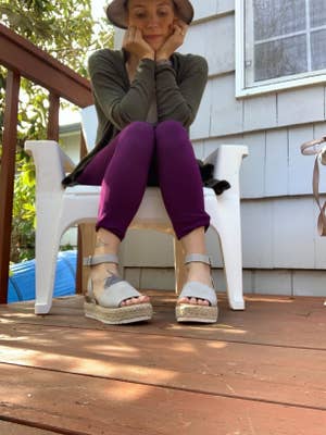 reviewer in white platform sandals while sitting on deck