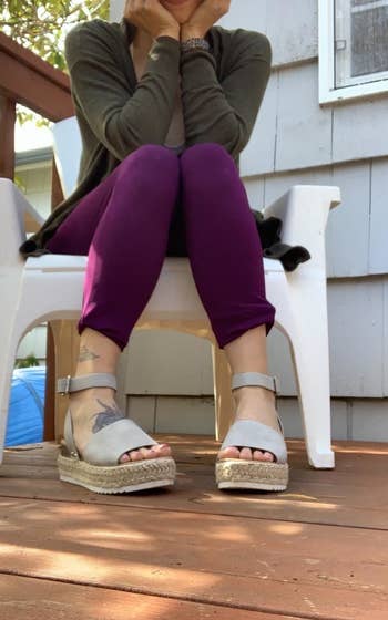 reviewer in white platform sandals while sitting on deck