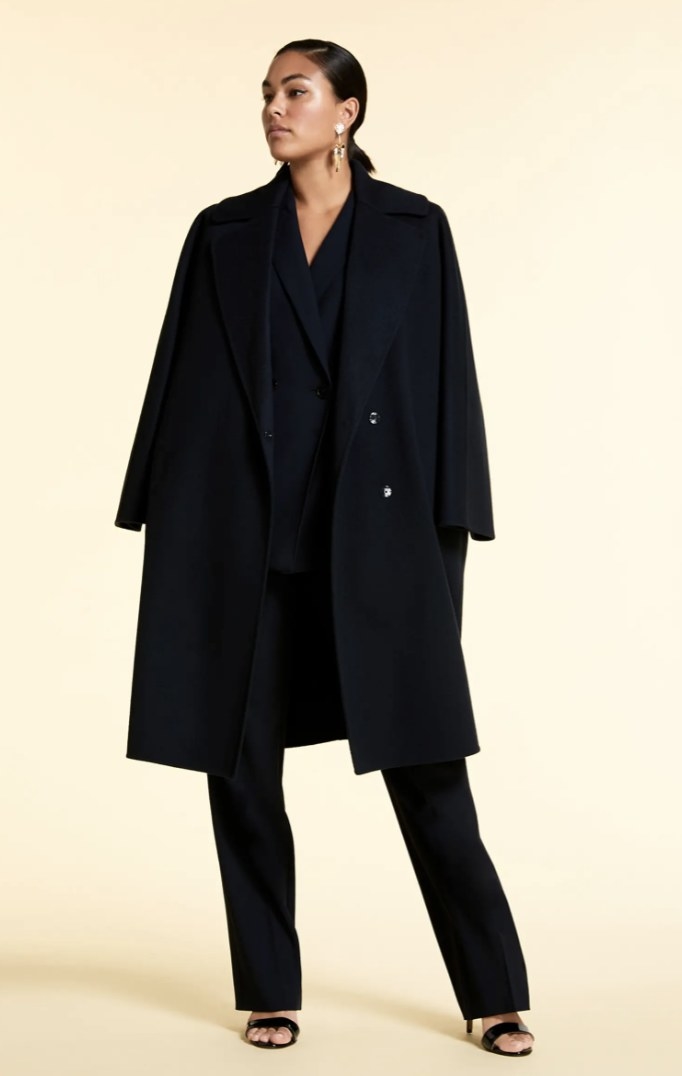 a model wearing the coat with an all black ensemble 