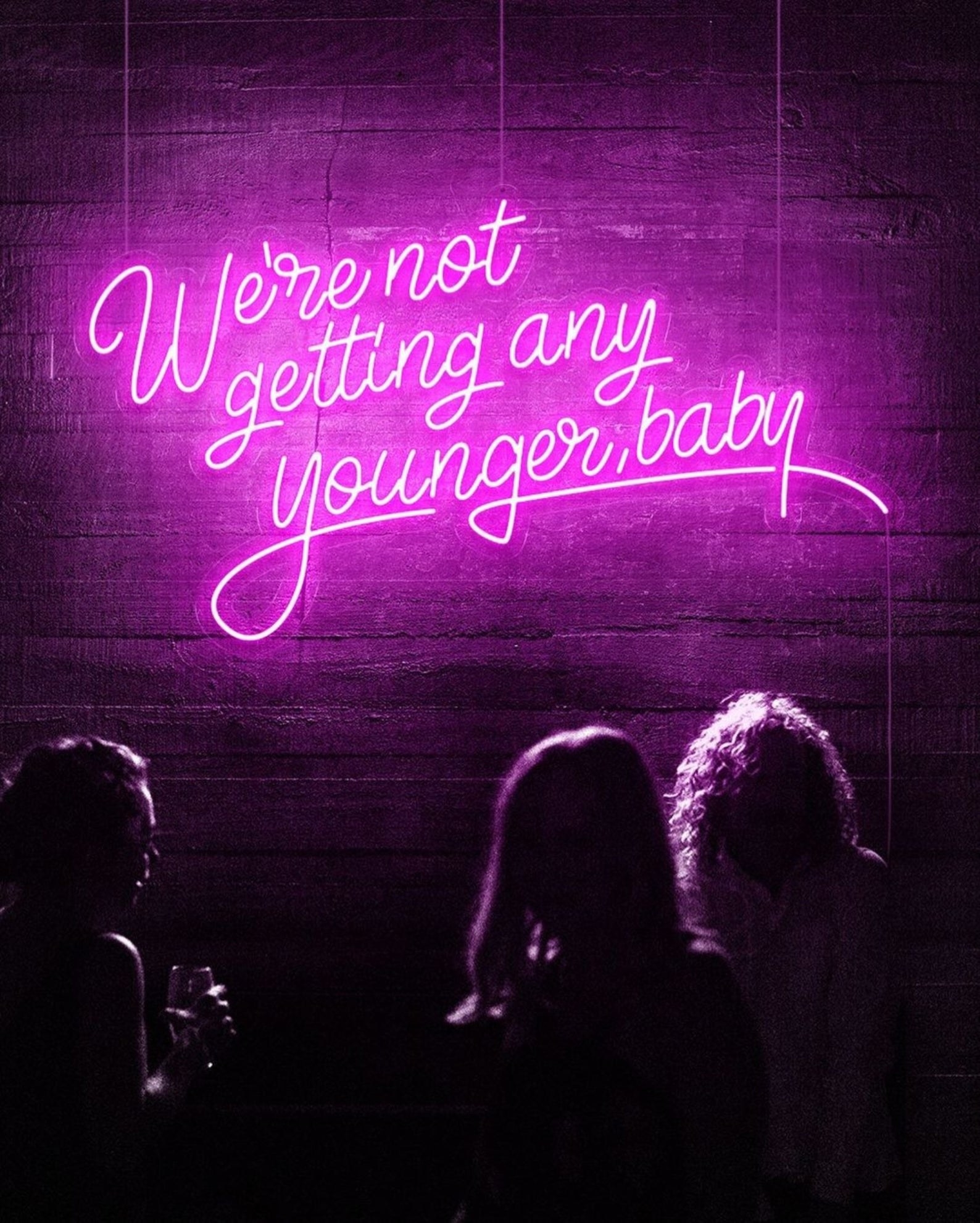 the neon sign which reads we're not getting any younger baby