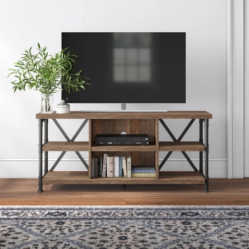 TV stand with wood shelves and metal legs with a TV on top