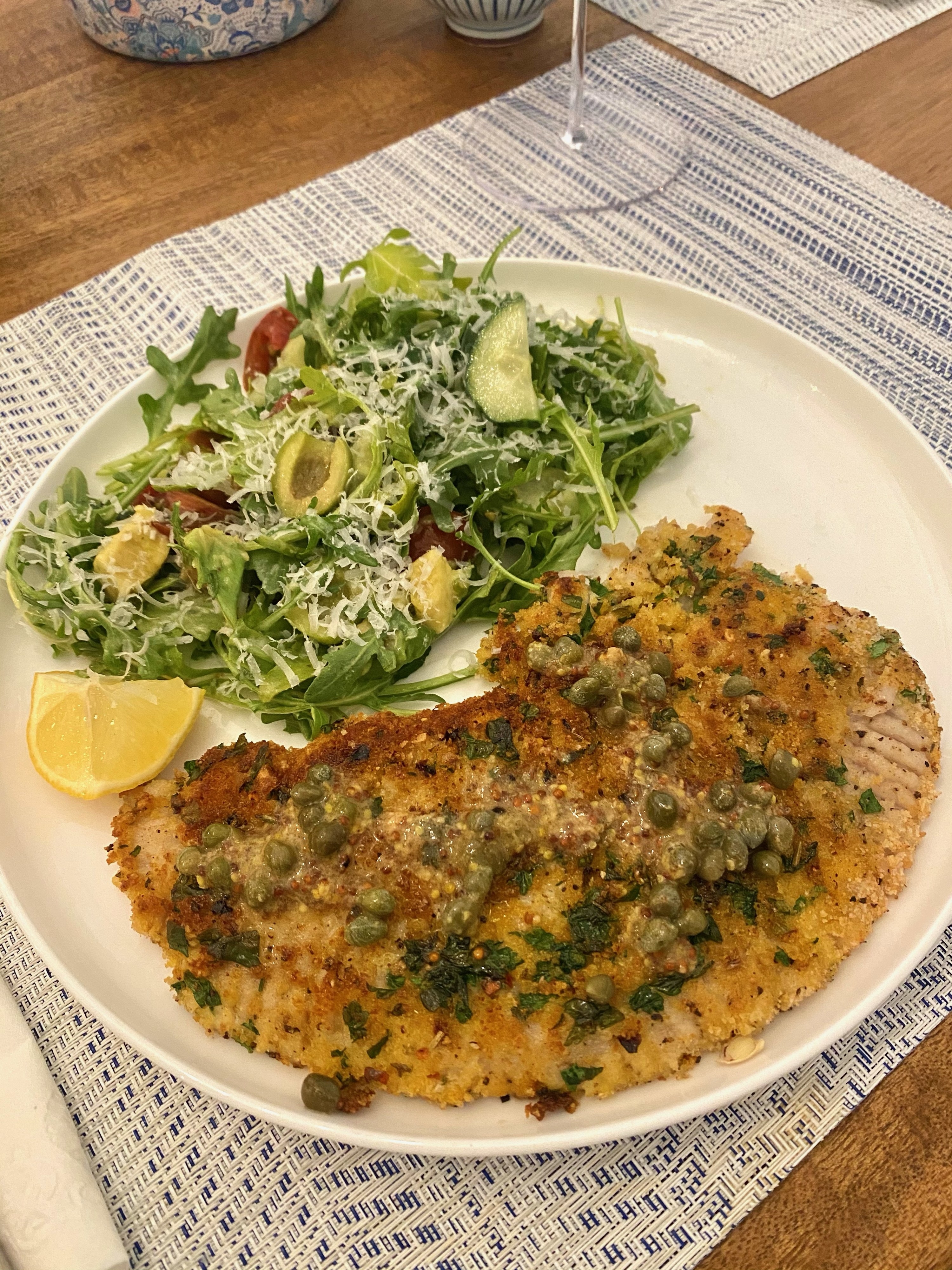 Skate wing Milanese topped with caper butter and a side salad.