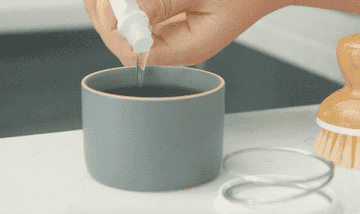 gif of person adding soap to dish, filling with water, and pressing down with brush to create bubbles