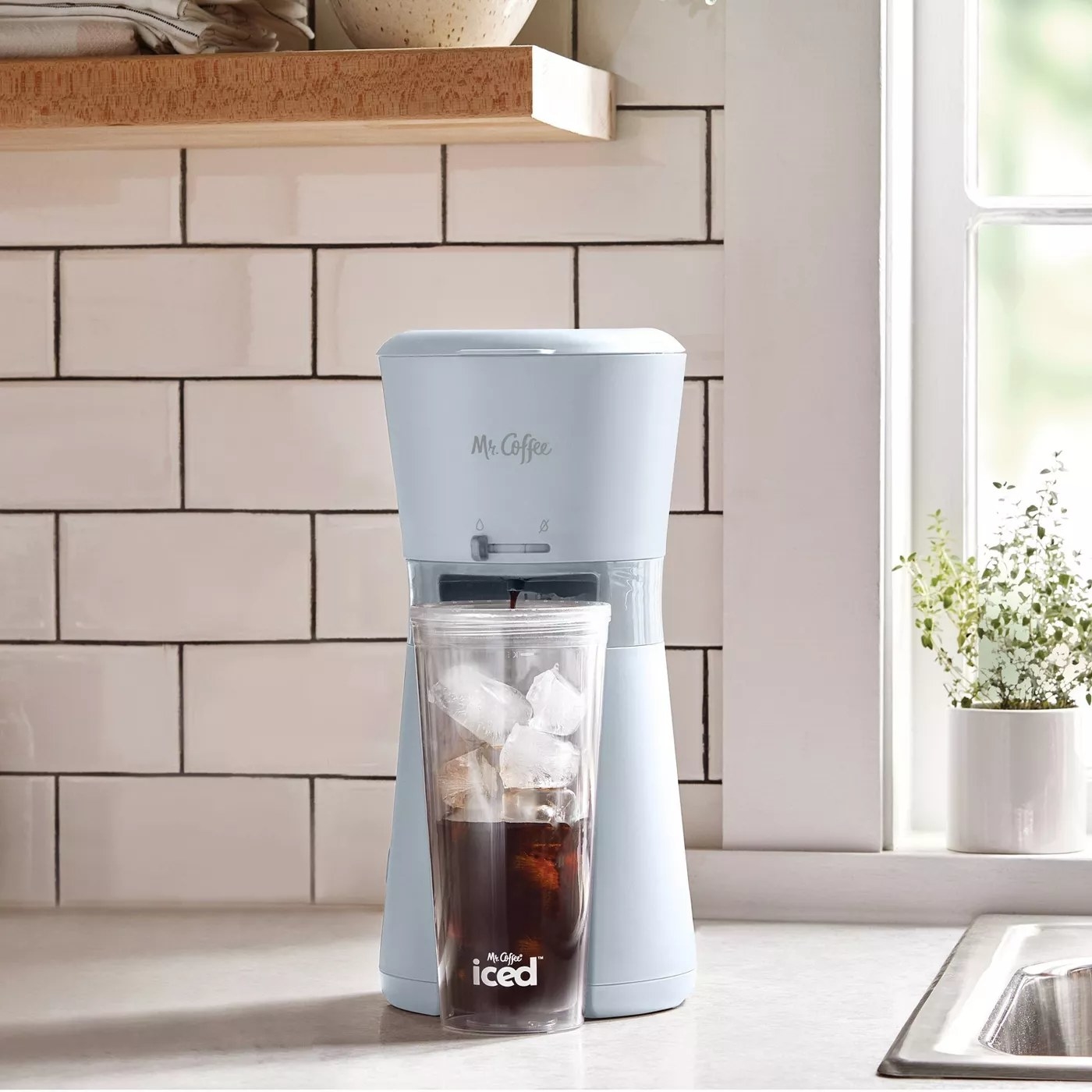 The iced coffee maker with a tumbler making a cup of coffee