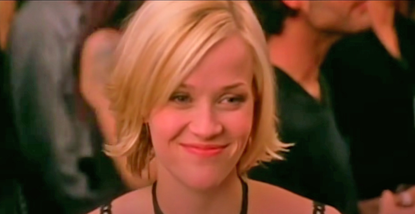 Reese Witherspoon smiling a closed mouth smile as Melanie