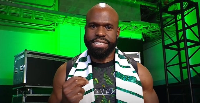 Apollo Crews wearing a green and white scarf