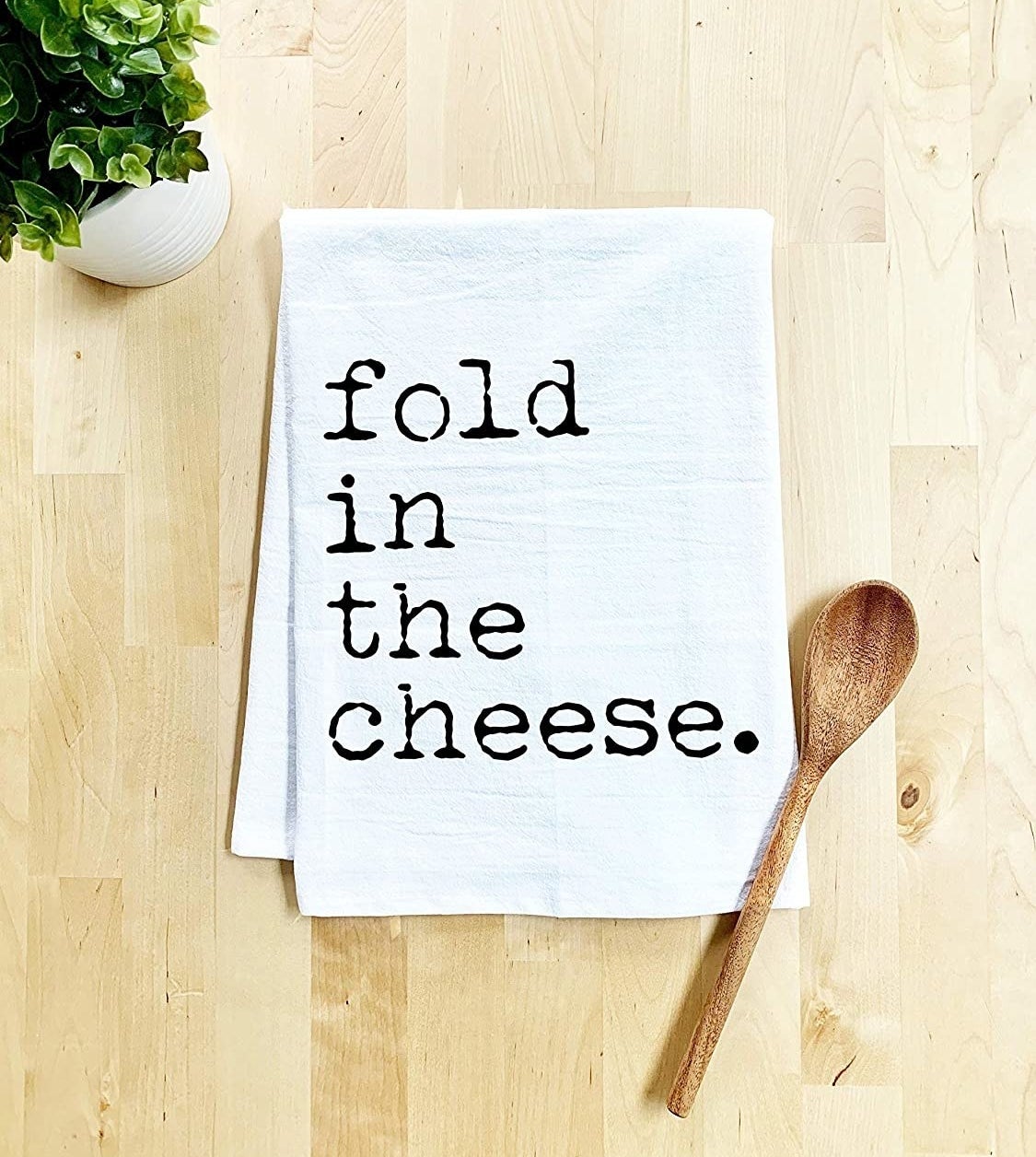 white towel that reads &quot;fold in the cheese&quot;