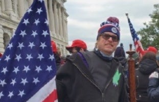 A man holds an American flag outside the US Capitol