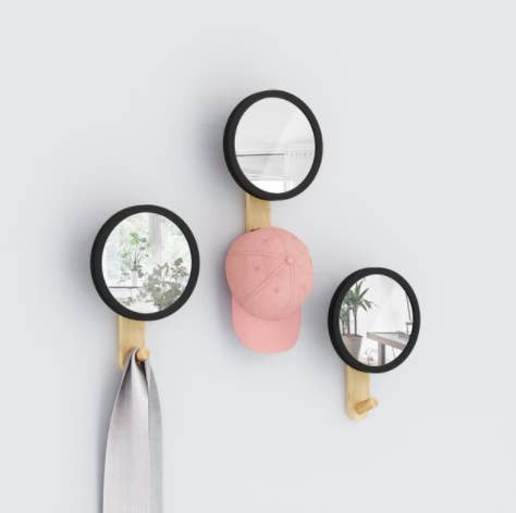 A trio of circular wall mirrors with tiny hooks at their base